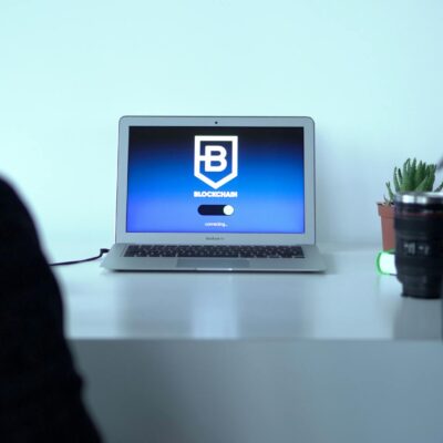 Colleagues discussing blockchain technology with a laptop in a modern office setting.